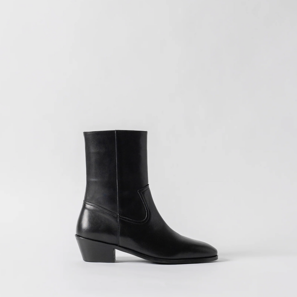 Black leather ankle boot on a light gray background