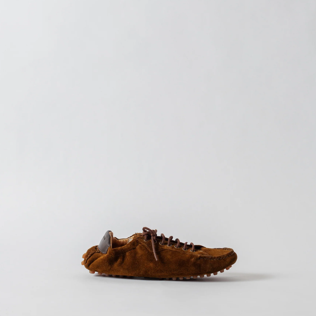 Brown suede shoe on a light gray background